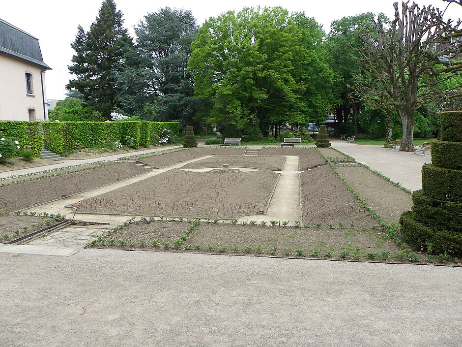 Vue de la mosaïque en cours de préparation dans la "partie basse" du square Emile Lechten. Il est possible d'apercevoir le piquetage de petits bois servant à matérialiser le dessin qui sera réalisé. Photo prise le 2 mai 2018. - Agrandir l'image, . 0octets (fenêtre modale)